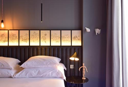 a bedroom with a bed with white pillows and a table at Pestana CR7 Funchal in Funchal