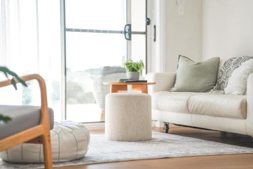 a living room with a couch and a table at Diggers Beach Villa Coffs Harbour in Coffs Harbour