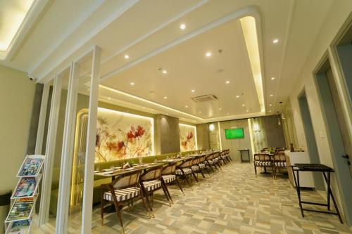 a large dining room with tables and chairs at Hotel Homansh by Goldsum in Lucknow
