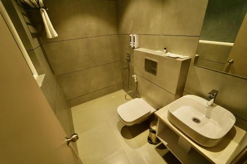 a small bathroom with a toilet and a sink at Hotel Homansh by Goldsum in Lucknow