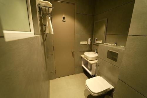 a small bathroom with a toilet and a sink at Hotel Homansh by Goldsum in Lucknow