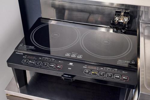 a black microwave oven with a control panel at Stylish Room Near Susukino 2 Beds 205 in Sapporo