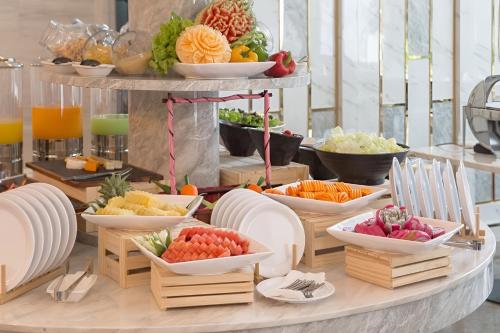 un buffet con ciotole di frutta e verdura su un tavolo di Elong Hotel -Jomtien Beach Branch a Na Jomtien