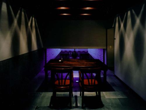 a dark room with a wooden table and chairs at 小樽旅亭 蔵群 in Otaru