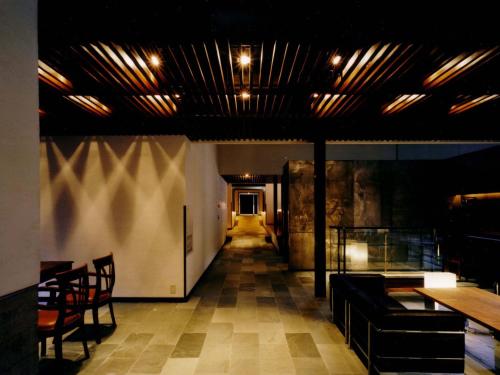a room with a hallway with a table and chairs at 小樽旅亭 蔵群 in Otaru