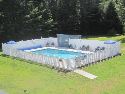 uma grande piscina com uma cerca branca à volta em North Colony Motel and Cottages em Bartlett
