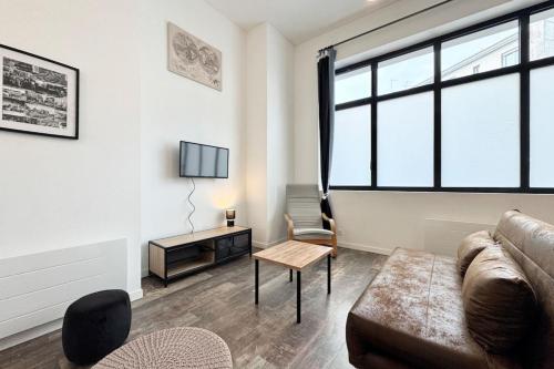 un salon avec un canapé et une table dans l'établissement Joli T2 esprit loft design & confort, à Lorient