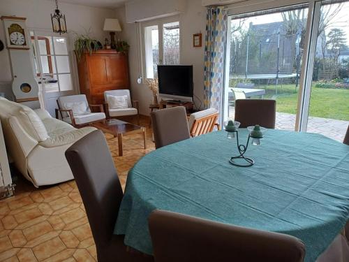 un salon avec une table et un tissu de table vert dans l'établissement Maison T3 avec jardin 5 minutes de Vannes, à Saint-Avé