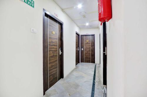 a hallway with two doors and a fire extinguisher at Collection O MVP Double Road in Gomti Nagar