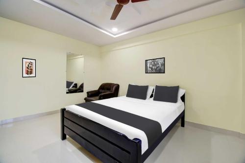 a bedroom with a bed and a chair in it at Collection O Murali Nagar Near NAD Junction in Visakhapatnam