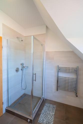 a bathroom with a shower in a attic at Künszler Apartmanház in Zamárdi