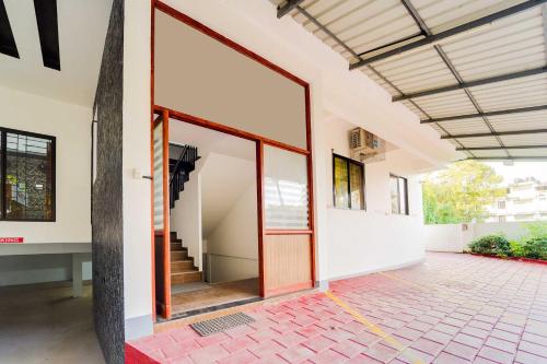 an open entrance to a house with a glass door at Collection O Cheranelloor Aster Medicity in Elūr