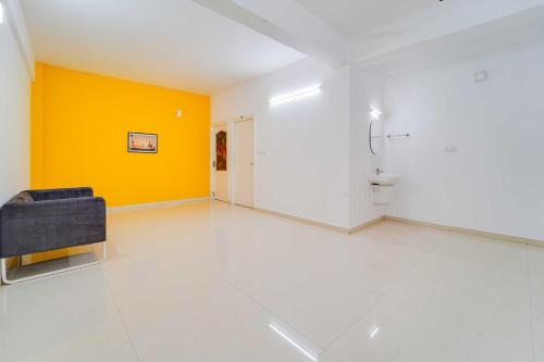 a bathroom with a shower and a yellow wall at Collection O Cheranelloor Aster Medicity in Elūr