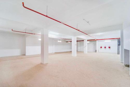 an empty room with white walls and white columns at Collection O Cheranelloor Aster Medicity in Elūr