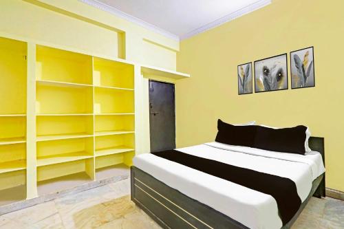a bedroom with yellow shelves and a bed at Collection O Near Dilsuknagar Metro in Hyderabad