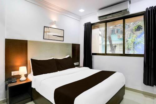 a bedroom with a large bed and a window at Collection O Four Bungalow in Upal