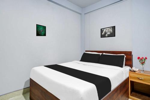 1 dormitorio con 1 cama y mesita de noche de madera en Collection O Lapalang Shillong, en Pynursla