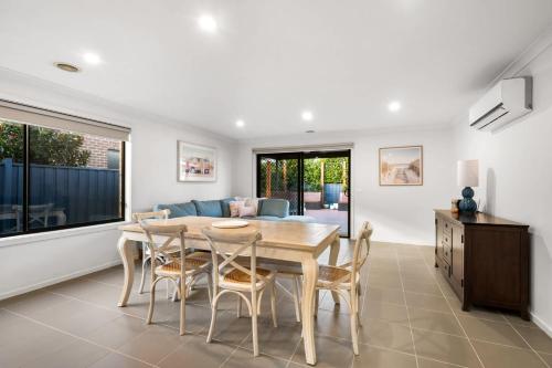 a dining room with a table and chairs and a couch at Family-Friendly 4BR Mount Duneed Manor in Mount Duneed