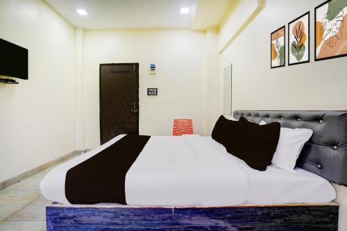 a bedroom with a bed with a black and white comforter at Collection O Jaggannath Temple Formerly Silver Key in Raipur