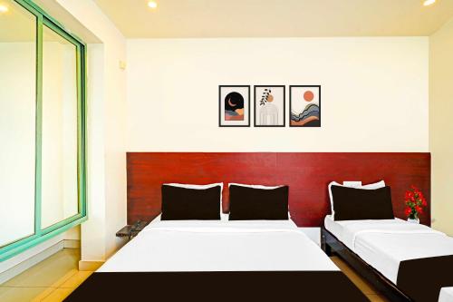 a bedroom with two beds and a large window at Collection O Kaveri Road Mysore in Mysore