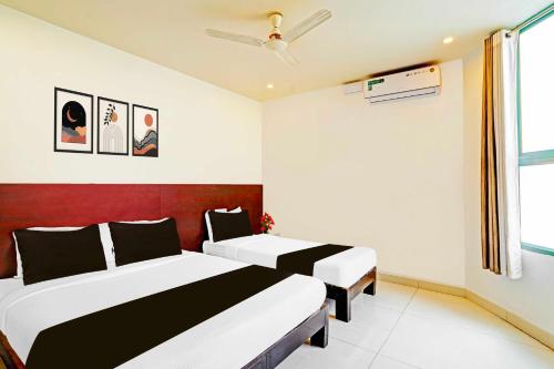 a bedroom with two beds and a window at Collection O Kaveri Road Mysore in Mysore