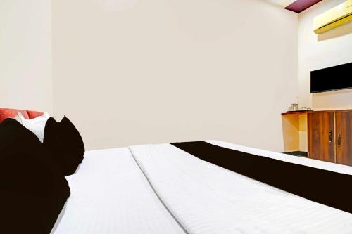 a bedroom with a bed with white sheets at Collection O Hanuman Naka Ujjain in Ujjain