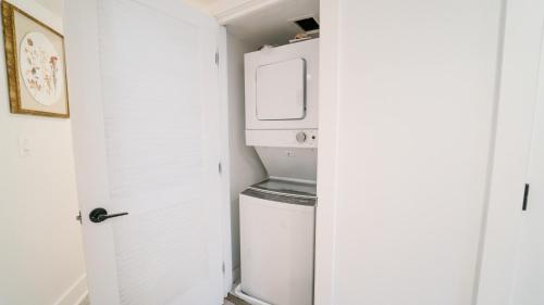 a small white laundry room with a washer and dryer at Cozy 1BR 1BA Retreat in a Private DC Basement in Washington, D.C.
