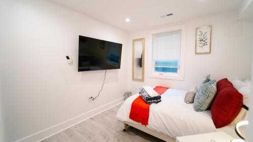 a bedroom with a bed and a flat screen tv at Cozy 1BR 1BA Retreat in a Private DC Basement in Washington, D.C.
