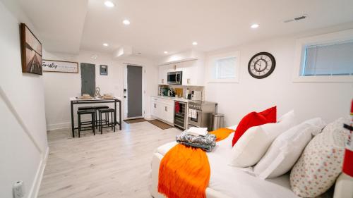 a living room with a white couch and a kitchen at Cozy 1BR 1BA Retreat in a Private DC Basement in Washington, D.C.