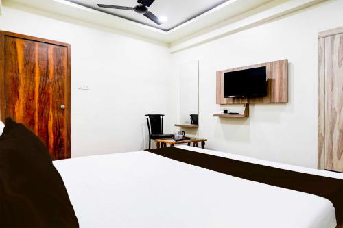 a bedroom with a bed and a flat screen tv at Collection O Dombivali in Mumbai