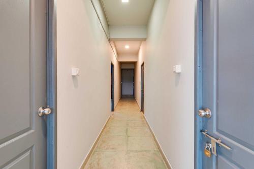 a corridor of an empty hallway with two doors at Collection O ECR Stays Near Nemmeli Beach in Chennai