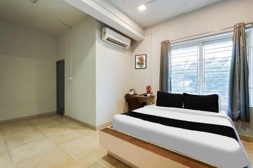 a bedroom with a large bed and a window at Collection O ECR Stays Near Nemmeli Beach in Chennai