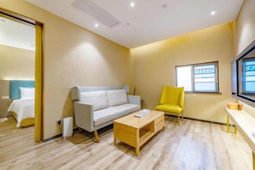a living room with a couch and a yellow chair at ZMAX Hotels Shenzhen Lianhuacun Metro Station in Shenzhen