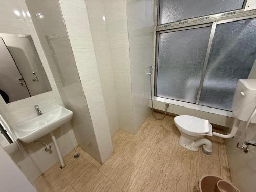 a bathroom with a toilet and a sink at Hotel Alohi Grand in Guwahati