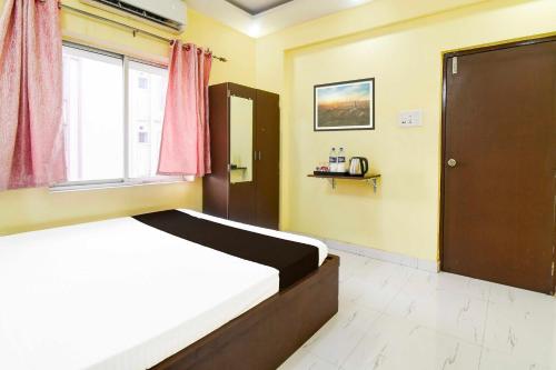 a bedroom with a bed and a window at Collection O New Town Near Kolkata Airport in kolkata