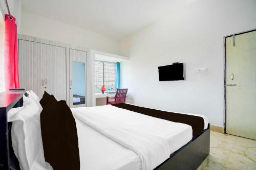a bedroom with a large bed with a tv on the wall at Collection O Dumduma Near DN Regalia Mall in Bhubaneshwar
