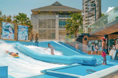 a group of people riding a water slide at a water park at Wekata Luxury in Kata Beach