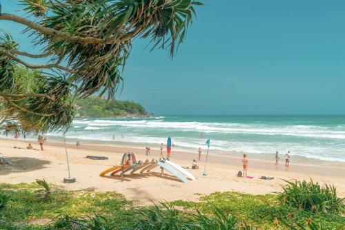 a group of people on a beach with surfboards at Wekata Luxury in Kata Beach
