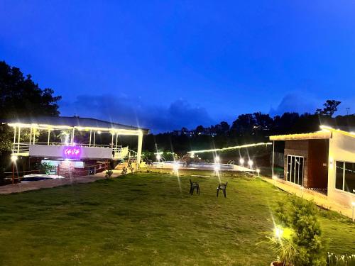 a building with lights in a field at night at Glenvista Estate in Panchgani
