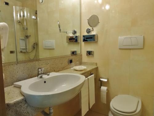 La salle de bains est pourvue d'un lavabo et de toilettes. dans l'établissement Hotel Tiffany Milano, à Trezzano sul Naviglio