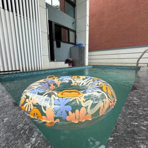 a swimming pool with a colorful floor in front of a building at Sea, Hill & Forest View Villa in Dongri