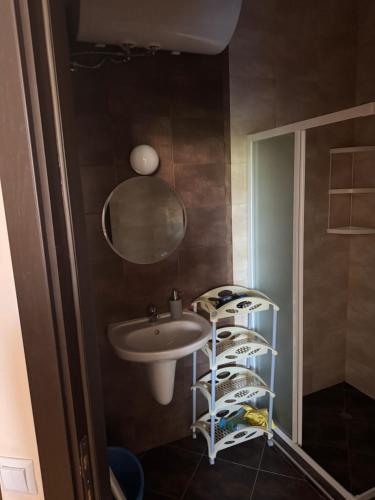 a bathroom with a sink and a mirror and a shelf at Центр солнечного берега in Sunny Beach