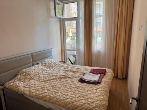 a bed in a room with a window and a bedvisor at Центр солнечного берега in Sunny Beach