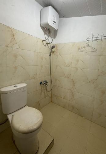 a bathroom with a toilet and a water tank at Nuwono Tasya Syariah in Bandar Lampung
