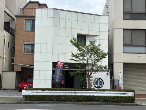 a white building with a tree in front of it at 梅の宿Umenoya PC1 in Odawara