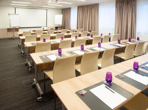 a classroom with tables and chairs and a whiteboard at INNSiDE by Meliá Aachen in Aachen