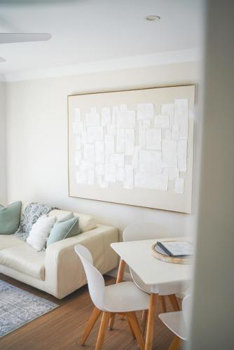 a living room with a couch and a table at Diggers Beach Villa Coffs Harbour in Coffs Harbour