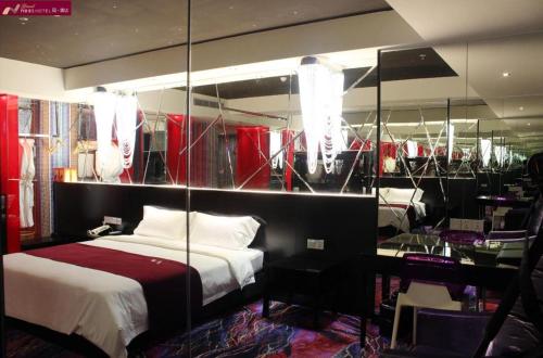 a bedroom with a bed and a mirror at Grand Nest Hotel (Tang Jia Wan Beach) in Zhuhai