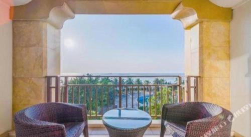 a balcony with two chairs and a table on a balcony at Ocean Spring Metropark Hotel Zhuhai in Zhuhai