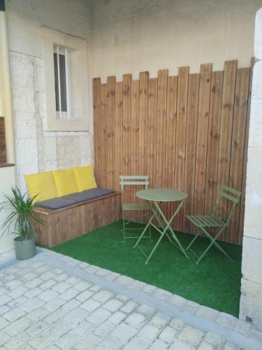un patio avec une table et des chaises et une clôture dans l'établissement Le petit cozy, à La Roche-Chalais